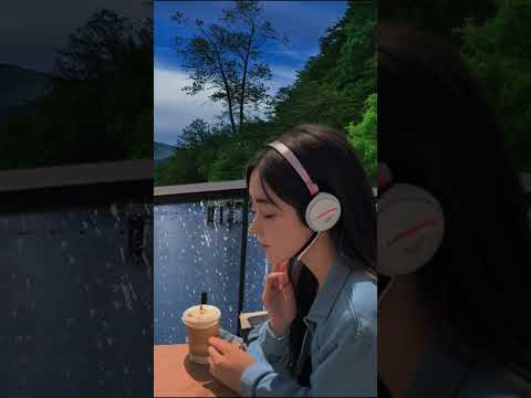 A girl and Rain sitting in a lake view cafe listening to music